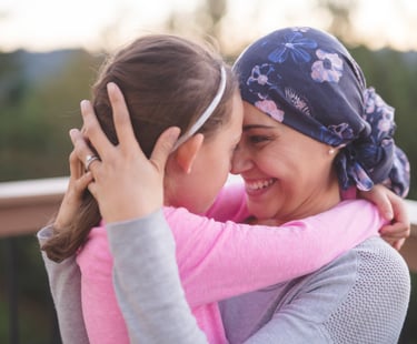 Mother in purple head scarf embraces daughter - holistic medicine for cancer Roaring Fork Valley CO