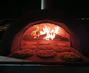 pizzas being cooked in our woodfired pizza oven pizza near me pizza shop near me caterer near me