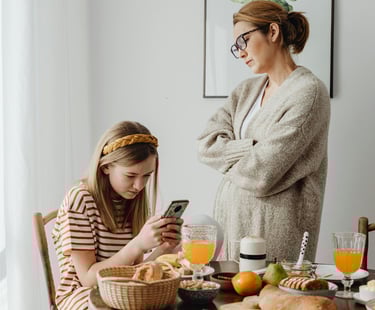 a woman and her daughter are sitting at a table