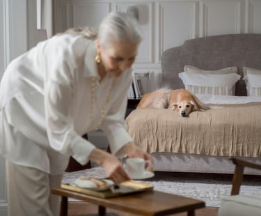 a woman in a white shirt and a dog on a bed