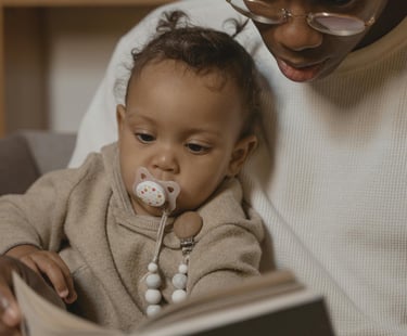 a woman is sitting on a couch while reading a book
