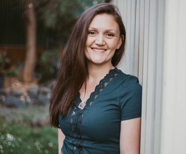 a woman in a green dress smiling and looking at the camera