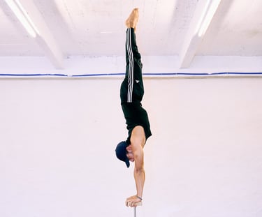 Man voert een rechte handstand uit op canes bij De Polecats Fabriek in Gent