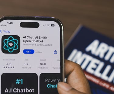 Hand holding an iPhone displaying an AI Chat chatbot app on the Apple App Store next to an artificial intelligence book.