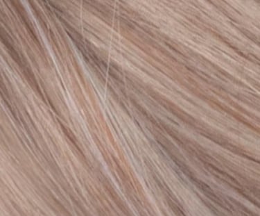 Close-up texture of wavy light ash blonde hair with subtle strawberry highlights.