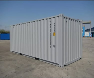 A light grey 20ft steel shipping container for storage and freight sitting on a concrete pad.