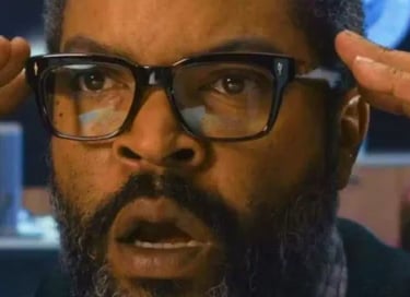 Ice Cube with a shocked expression and hands raised to his head, reacting to intense news in a scene