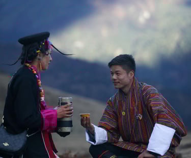 Layap-women-in-Bhutan-with-a-traditional-gesture-of-welcoming-a-guest-serving-local-wine-ara