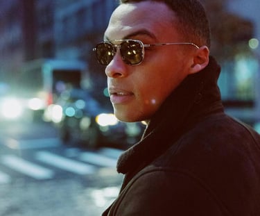 Man walking at night in the street, wearing stylish eyewear