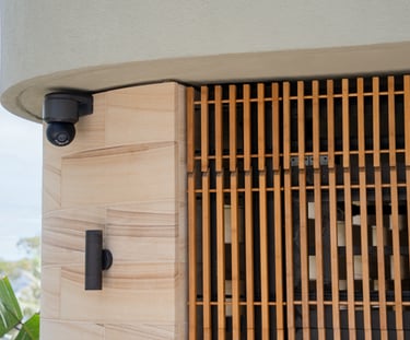 a camera mounted to a wall near a building