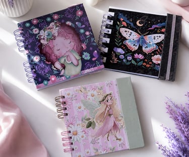 Collection of colorful spiral notebooks featuring whimsical fairy, moth, and girl power designs.