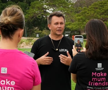 Local business owner speaking on camera while being filmed for social-first content outdoors