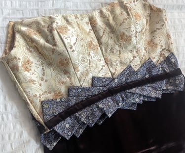 The front of the bodice of a gold brocade and brown satin evening gown