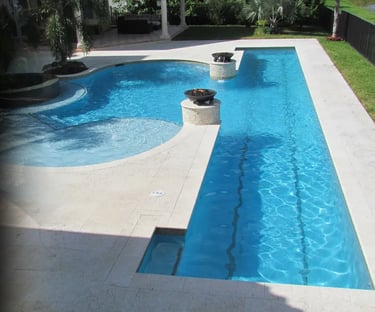 Geometric pool with integrated spa, light aqua water, cream stone coping and blue mosaic tiles