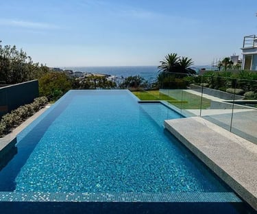 Geometric Infinity-edge pool with bright turquoise water and mosaic blue tiles