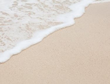 vague douce sur le sable illustrant l’accompagnement bienveillant d’une sophrologue spécialisée