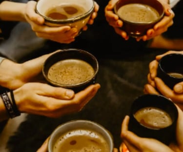 Many hands sharing a cup of cacoa