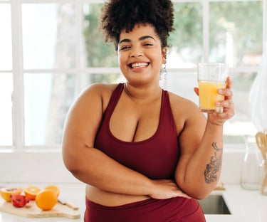 Woman in red tank top drinks juice happily after her holistic medicine treatment Carbondale, CO