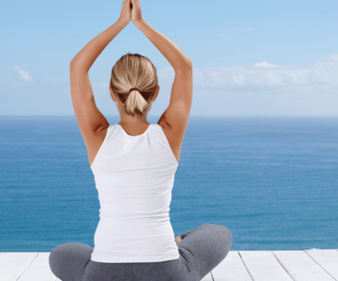 a woman sitting on a deck deck overlooking the ocean