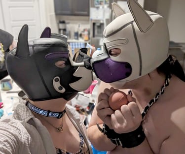 Two people in pup hoods rubbing snouts.