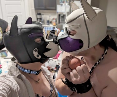 Two people in pup hoods rubbing snouts.