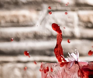 Schizzo rosso da un cocktail in cristallo con fiore di ciliegio – fotografia emozionale e dinamica a