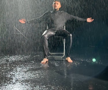 homme sur fond noir avec de la pluie artificielle