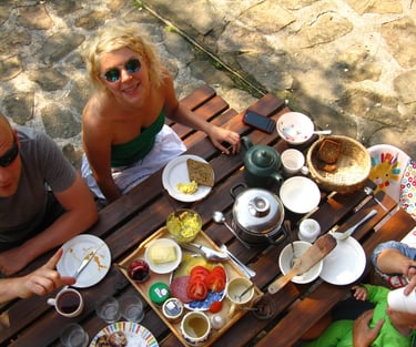 Rodzina delektująca się śniadaniem na świeżym powietrzu przy rustykalnym drewnianym stole