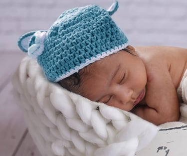 Adorable newborn baby peacefully sleeping in a cozy wrap at Pixel Craft Digital Studio.