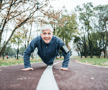 Woman with short white hair does push ups in park in Basalt, CO after acupuncture for menopause