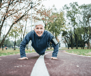 Woman with short white hair does push ups in park in Basalt, CO after acupuncture for perimenopause