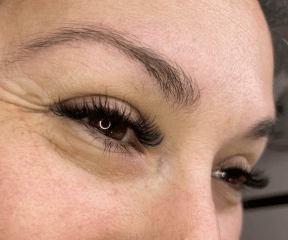 femme recevant un service de pose de cils dans un salon de beauté Natural-looking lashes