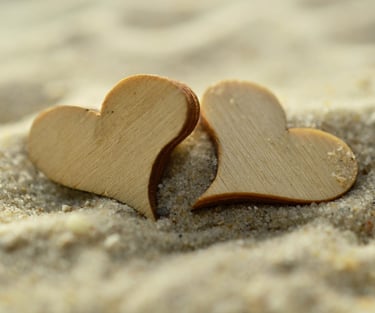 deux petits coeurs en bois posés sur du s
