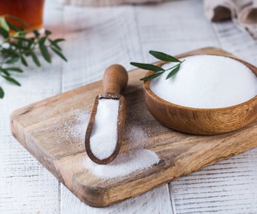 a wooden bowl with stevia and a wooden spoon