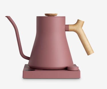 Matte pink electric gooseneck kettle with light wood handle and base for pour-over coffee brewing.