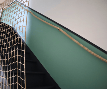 Escalier intérieur moderne reliant les étages d’un logement meublé spacieux.