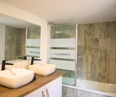 Salle de bain équipée avec baignoire et double vasque pour séjour professionnel.