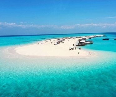 A stunning aerial view of Nakupenda Sandbank in Zanzibar, Tanzania, showcasing pristine white sand, turquoise waters