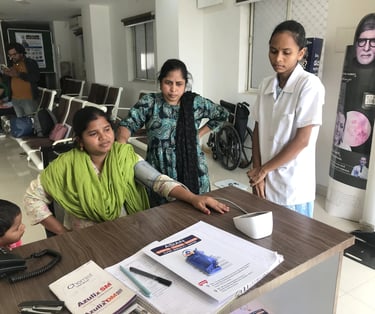 Nurse checking patient blood pressure before seeing Dr. Shalini at Madinaguda branch