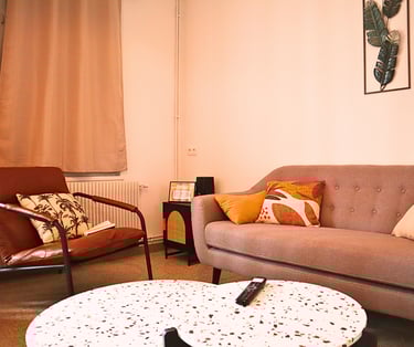 Coin salon cosy avec canapé et fauteuils dans hébergement pour équipes en mission.