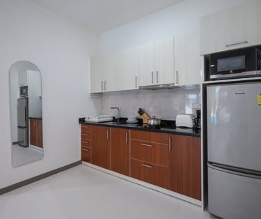 Kitchen with large fridge, hob, and microwave.