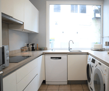 Cuisine moderne équipée avec lave-vaisselle et lave-linge pour séjour professionnel.