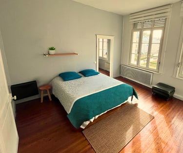 Chambre double spacieuse avec lit confortable et parquet dans maison meublée.