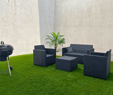 Espace extérieur privatif avec salon de jardin et barbecue dans logement professionnel.