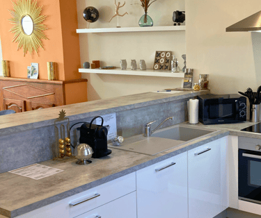 Cuisine moderne équipée avec électroménagers et plan de travail pratique.