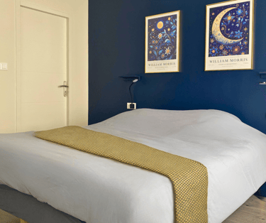 Chambre double cosy d’appartement meublé avec lit confortable et décoration élégante.