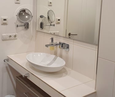 Das Bad mit Waschbecken, Schrank und Kosmetikspiegel