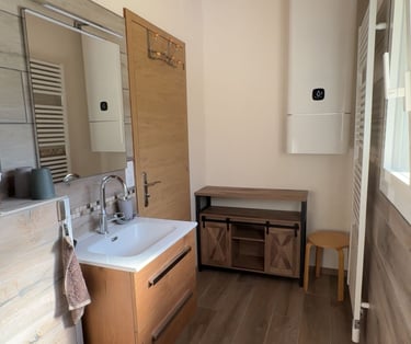 Salle de bains avec grand chauffe-eau et sèche-serviettes fonctionnel.