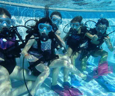 a group of scuba divers in a pool