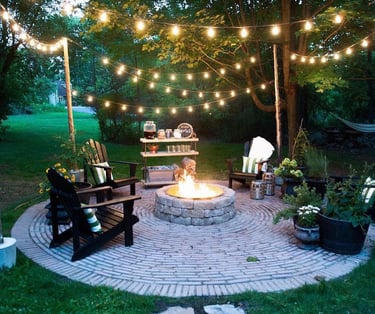 a fire pit with chairs and lights on it